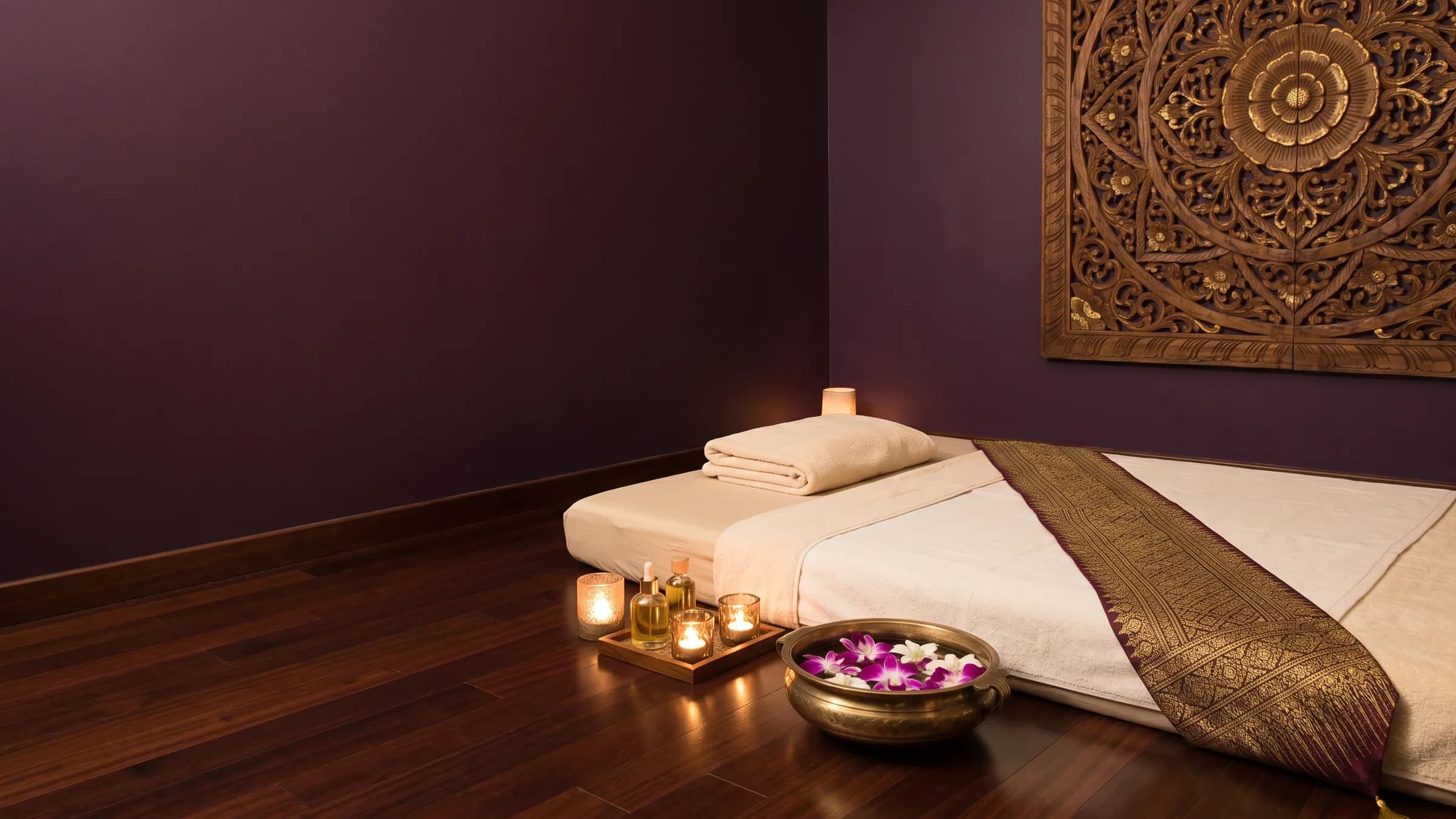 A treatment room at Pimmy Massage with a mat, candles and orchids